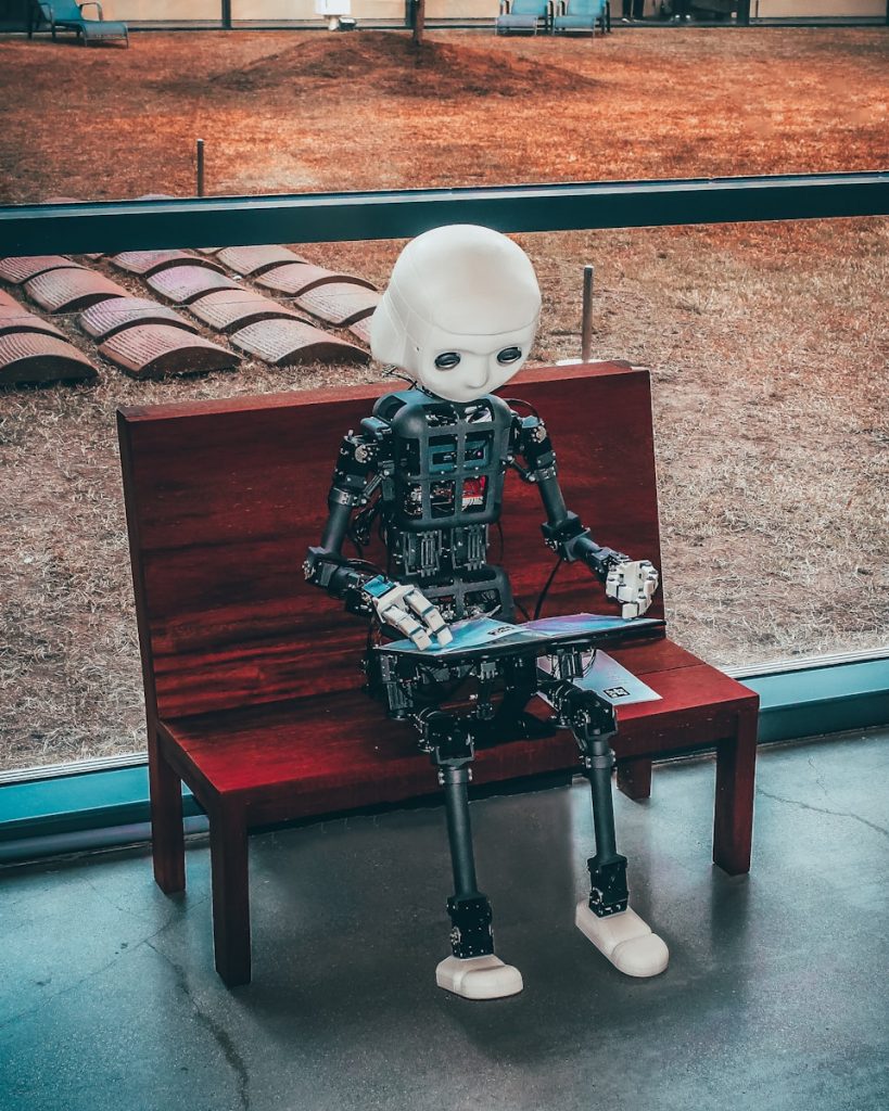 black and white robot toy on red wooden table using AI to write a better blog post