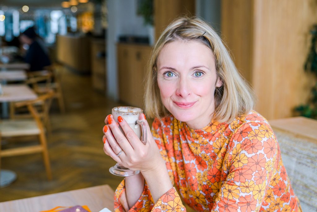 Portrait of Genevieve White, travel, tourism and hospitality copywriter, drinking coffee in local cafe.