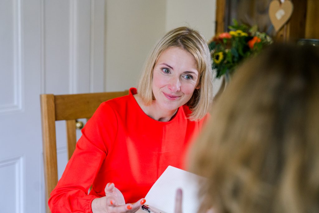 Close-up of Genevieve coaching a travel business owner, asking questions to unlock their authentic voice