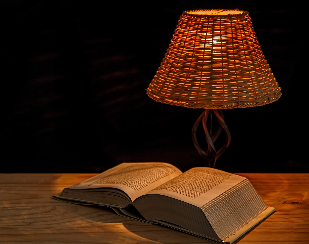 Open book under glowing lamp representing how personal voice comes alive in writing
