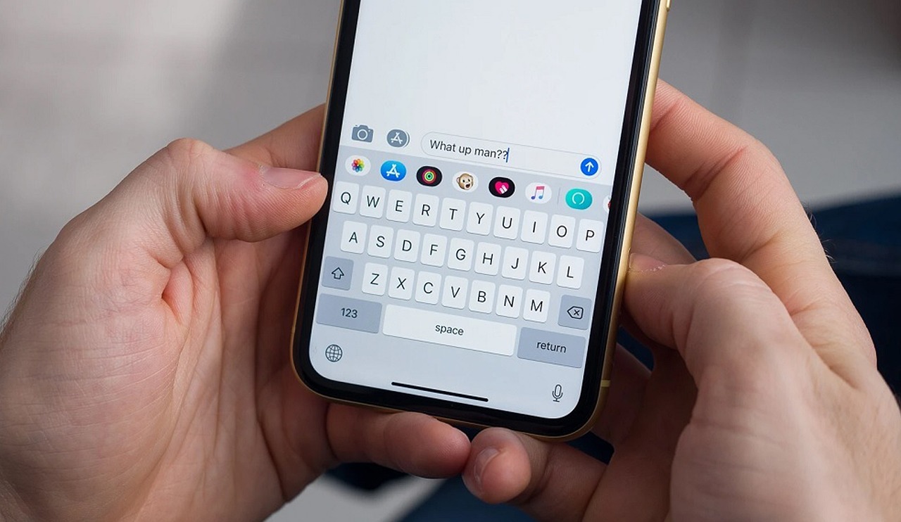 Hands holding smartphone composing informal text message showing natural voice patterns for voice audit analysis