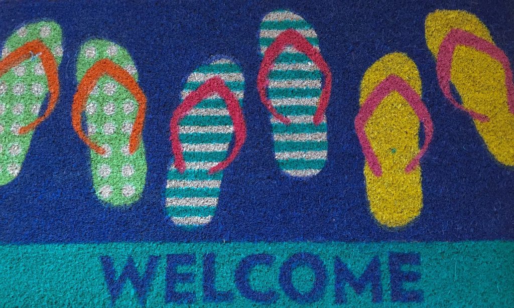 Colourful welcome mat with flip-flop prints representing consistent hospitality voice
