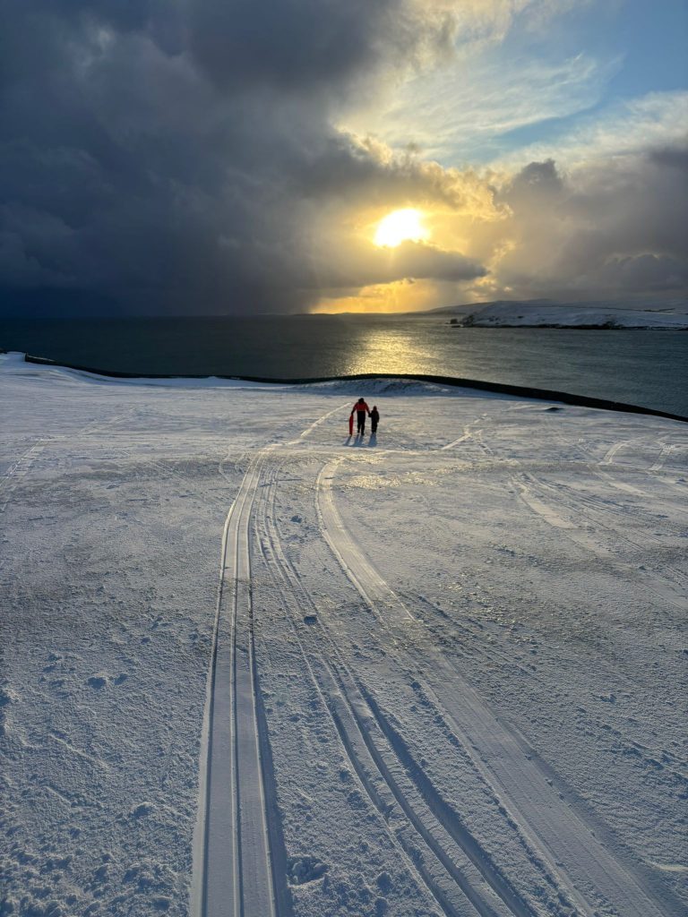 Snowy Shetland landscape at sunset with two walkers - the everyday beauty tourism businesses think is too ordinary to share